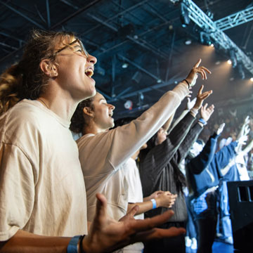people in the crowd singing at concert